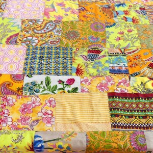 Peut inclure: Une courtepointe patchwork avec une vari&eacute;t&eacute; de motifs floraux et g&eacute;om&eacute;triques color&eacute;s. La courtepointe est compos&eacute;e de carr&eacute;s de tissus diff&eacute;rents, cousus ensemble pour cr&eacute;er un design unique et int&eacute;ressant.