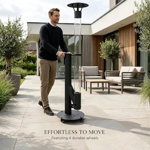 Pode incluir: Um aquecedor de exterior cilíndrico, alto e preto, com uma secção de tubo de vidro transparente, uma base circular e quatro rodas pequenas. A unidade possui uma estrutura de metal preto e uma tampa superior. O texto diz EFFORTLESS TO MOVE.