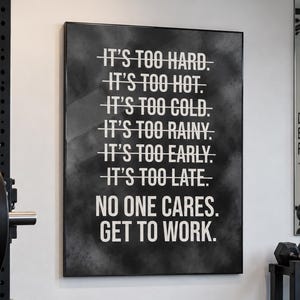 May include: A rectangular wall art print with a black background and white text that reads: IT'S TOO HARD. IT'S TOO HOT. IT'S TOO COLD. IT'S TOO RAINY. IT'S TOO EARLY. IT'S TOO LATE. NO ONE CARES. GET TO WORK. Each line except the last is crossed out.