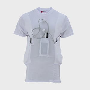 Op de afbeelding: Een wit T-shirt met korte mouwen en een centrale verticale zak voor een medisch apparaat. Een grijze kabel loopt vanuit de zak omhoog en wordt vastgehouden door kleine lussen op de borst. Het label in de nek bevat de tekst LVADGear.