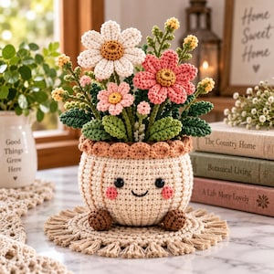 Puede incluir: Un arreglo floral de ganchillo en una maceta beige, redonda y sonriente con pequeños pies marrones. El ramo presenta una margarita blanca grande, una flor rosa y capullos más pequeños con hojas verdes sobre una alfombrilla redonda con flecos.