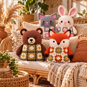 Peut inclure: Quatre animaux en peluche crochetés à la main assis sur un canapé. La collection comprend un ours brun, un chat gris, un lapin blanc aux oreilles roses et un renard orange et blanc. Chaque animal a un corps composé de motifs granny squares.