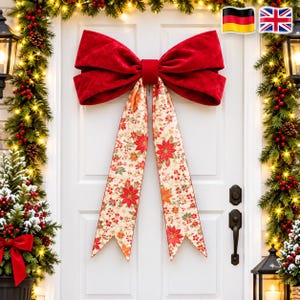 Op de afbeelding: Een grote decoratieve strik met een bovenkant van effen rood fluweel en twee lange, hangende linten van crèmekleurige stof met een patroon van rode kerststerren, groene bladeren en kleine rode bessen, bevestigd op een witte deur.