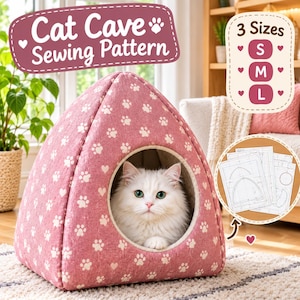 May include: A pink cat cave sewing pattern featuring a white paw print and heart motif. The structure is triangular with a circular opening containing a white cat. Text reads Cat Cave Sewing Pattern and 3 Sizes S M L.