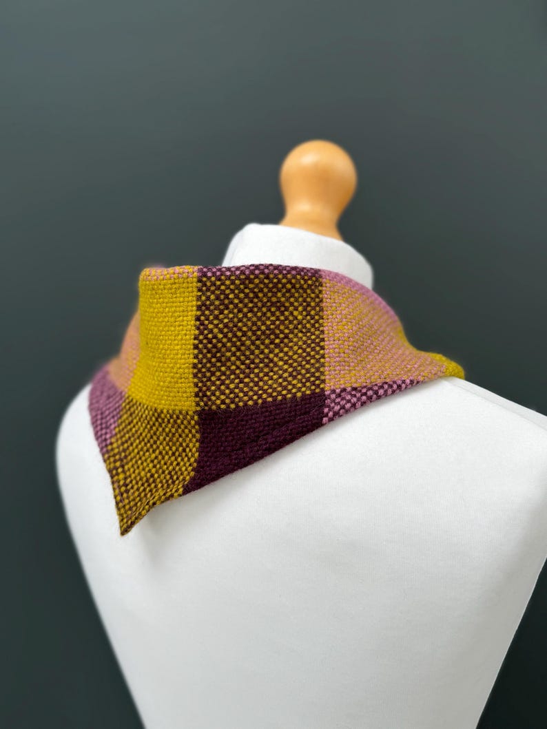 pink, yellow and burgundy triangle neckerchief tie on a mannequin against a dark grey background