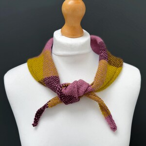 pink, yellow and burgundy triangle neckerchief tie on a mannequin against a dark grey background