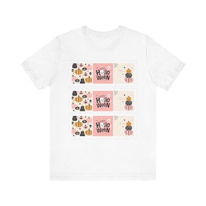 Könnte beinhalten: Ein weißes Kurzarm-T-Shirt mit drei identischen rechteckigen Grafikdrucken. Jeder Druck zeigt ein Muster aus kleinen Kürbissen, den Text "HAPPY HALLOWEEN" mit einem Geister-Symbol sowie einen Stapel aus drei orangefarbenen, schwarzen und rosafarbenen Kürbissen.