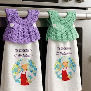 Puede incluir: Dos paños de cocina blancos con un gráfico de un chef con delantal rojo y el texto "MY COOKING IS SO Fabulous..." rodeado de flores azules. Cada paño tiene una parte superior de ganchillo en color morado o verde menta con dos botones blancos.