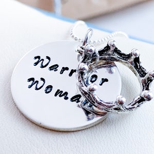 May include: Silver necklace with a round pendant that says "Warrior Woman" and a silver crown charm.