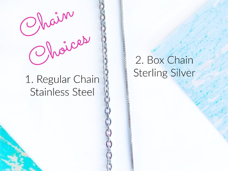 May include: Two silver chains, one regular chain made of stainless steel and one box chain made of sterling silver. The text "Chain Choices" is written in pink cursive above the chains. The text "1. Regular Chain Stainless Steel" is written below the first chain. The text "2. Box Chain Sterling Silver" is written below the second chain.