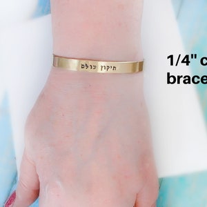 Showing the one quarter inch wide bracelet on a female wrist. El Roi Hebrew bracelet engraved with the Name of God, 'God Who Sees Me.' This inspirational Christian jewelry piece offers comfort and faith, making it a meaningful Bible verse bracelet.