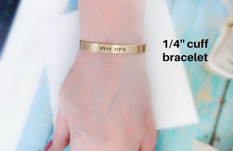Showing the one quarter inch wide bracelet on a female wrist. El Roi Hebrew bracelet engraved with the Name of God, 'God Who Sees Me.' This inspirational Christian jewelry piece offers comfort and faith, making it a meaningful Bible verse bracelet.