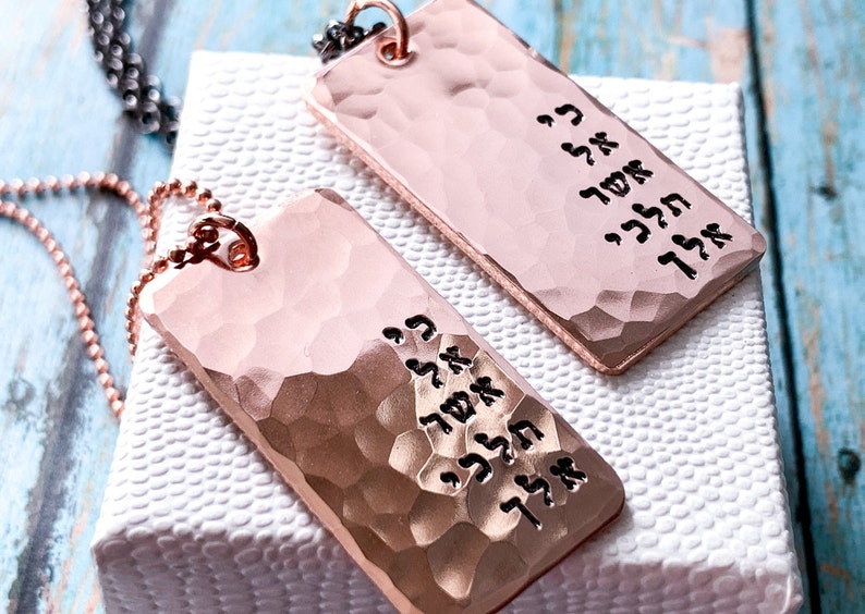 May include: Two rose gold necklaces with hammered rectangular pendants. Each pendant has Hebrew text engraved on it.