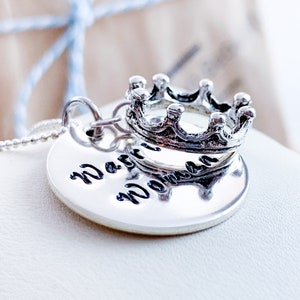 May include: A silver necklace with a round pendant that says "Warrior Woman" and a silver crown charm.