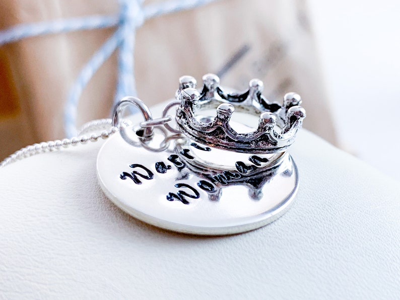 May include: A silver necklace with a round pendant that says "Warrior Woman" and a silver crown charm.