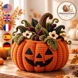 Könnte beinhalten: Ein gehäkelter orangefarbener Kürbis mit einem schwarzen Jack-o'-Lantern-Gesicht, verziert mit einem braunen Stiel, grünen Blättern, kleinen dunkelvioletten Beeren, weißen Blüten und Ranken. Das Logo von Muhammad Faizan Crochet Patterns ist sichtbar.
