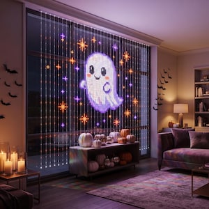 May include: A window curtain of LED lights displaying a pixelated white ghost surrounded by orange and purple star-shaped light accents. The light curtain hangs against a large window, illuminating the interior space with a festive glow.