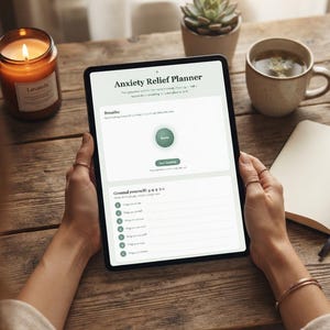 Puede incluir: Una tableta digital que muestra una interfaz de planificador de alivio de la ansiedad con secciones para ejercicios de respiración y una técnica de conexión a tierra 5-4-3-2-1. La pantalla presenta fondos blancos y acentos verdes.