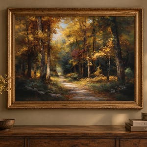 Könnte beinhalten: Ein rechteckiges Landschaftsgemälde in einem goldenen Rahmen, das einen Waldweg im Herbst darstellt. Die Szene zeigt hohe Bäume mit goldenem und braunem Laub, durch das Blätterdach gefiltertes Sonnenlicht und einen Pfad in der Ferne.