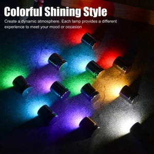 Può includere: Una collezione di piccole lampade cilindriche in metallo che emettono una luce vivace in rosso, blu, verde, viola, giallo e bianco. Il testo "Colorful Shining Style" e "Create a dynamic atmosphere. Each lamp provides a different experience to meet your mood or occasion" è visibile.