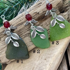 Pode incluir: Tr&ecirc;s enfeites de vidro do mar com asas de anjo prateadas e detalhes de folhas. Cada enfeite apresenta um tom diferente de vidro do mar verde. Uma conta vermelha adorna o topo de cada enfeite. Os enfeites est&atilde;o rotulados #1, #2 e #3.