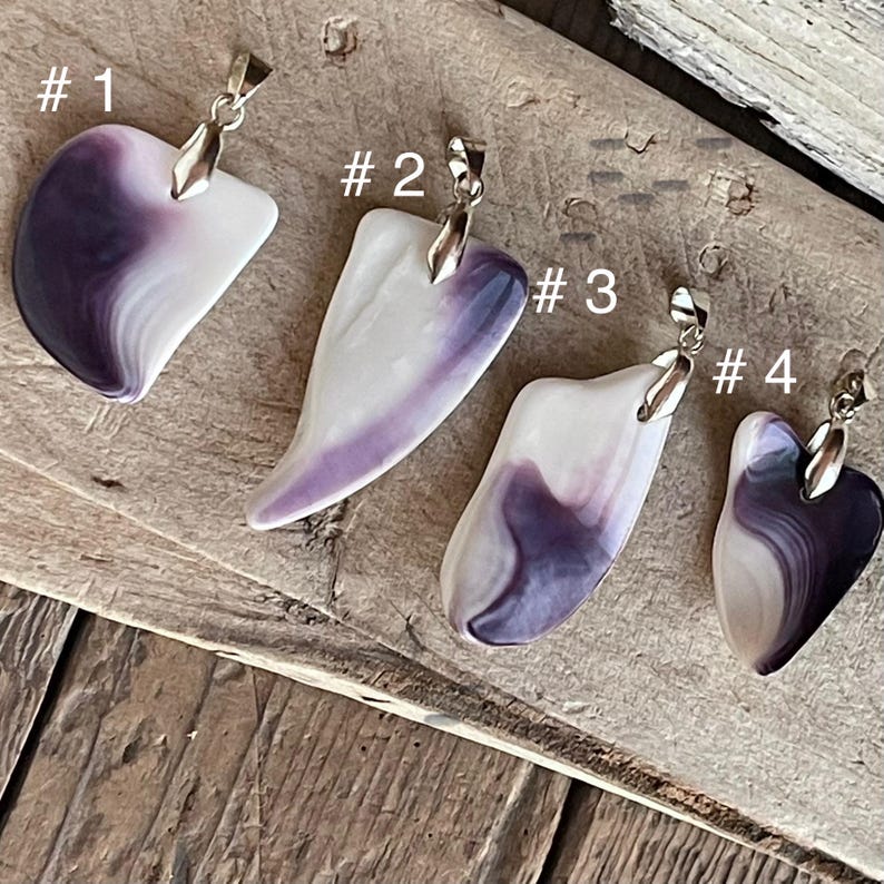 May include: Four pendants with silver-colored bails. Each pendant is a different shape, with a white base and purple marbling. The pendants are numbered 1 through 4.