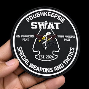 Könnte beinhalten: Ein kreisförmiger schwarz-weißer Aufnäher mit dem Text POUGHKEEPSIE SWAT, CITY OF POUGHKEEPSIE POLICE, TOWN OF POUGHKEEPSIE POLICE, SPECIAL WEAPONS AND TACTICS und EST. 2024. Die Mitte zeigt eine Grafik eines Adlers, der ein Gewehr hält.