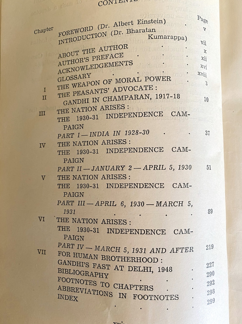 May include: Open book page with a table of contents. The text includes chapter titles and page numbers. Topics include Gandhi, independence, and related historical events. The book appears to be an academic or historical text.