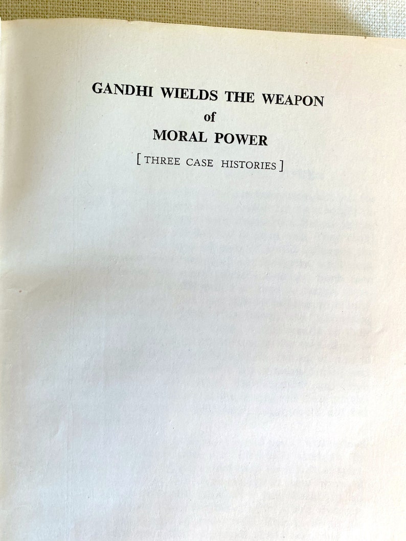 May include: Open book page with the title "GANDHI WIELDS THE WEAPON of MORAL POWER" in black text. Below the title is the text "[THREE CASE HISTORIES]" in black. The page is white.
