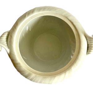 Pu&ograve; includere: Zuppiera in ceramica bianca con due manici decorati. La zuppiera ha un interno liscio e bianco e un esterno testurizzato.