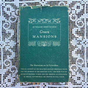 Könnte beinhalten: Ein grünes Hardcover-Buch mit dem Titel "Green Mansions" von William Henry Hudson. Der Buchumschlag zeigt einen dekorativen Rahmen mit Vögeln und Blättern. Der Text "The illustrations are by Covarrubias" ist am unteren Rand des Umschlags gedruckt.