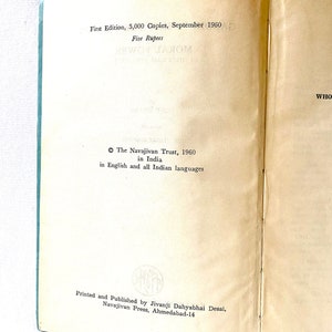 May include: Open book with text from the first edition of a book published in September 1960. The text includes the title, publisher, and price in rupees. The pages are off-white with a light blue spine.