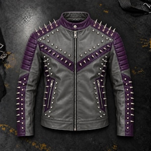 Puede incluir: Una chaqueta gris y morada con cuello alzado, cierre de cremallera central y dos bolsillos laterales con cremallera. La prenda está decorada con numerosos pinchos y tachuelas de metal plateado dispuestos en forma de V sobre el pecho.