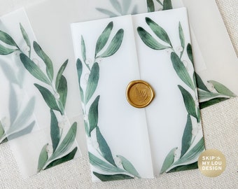 Puede incluir: Un juego de sobres de vitela blanca con un diseño de muérdago verde y un sello de lacre dorado. Los sobres son perfectos para invitaciones de boda u otras ocasiones especiales.