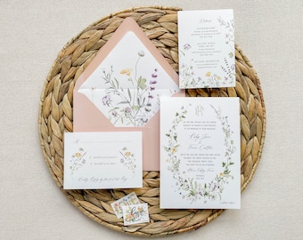 May include: A wedding invitation suite with a floral design. The invitation features a wreath of wildflowers and the text "Ruby Jane & Finn Collier". The details card features a similar floral design and the text "Details".