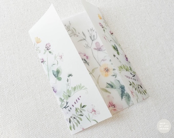 Op de afbeelding: Een gevouwen witte kaart met een aquarel bloemenontwerp. De kaart heeft delicate illustraties van wilde bloemen in tinten geel, roze en paars, met groene bladeren. De kaart is open en onthult de binnenpanelen.