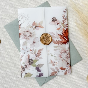May include: A white invitation card with a floral design in shades of pink, brown, and green. The card is sealed with a gold wax seal. The card is folded in half and has a light green envelope.