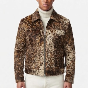 May include: A long-sleeve jacket featuring a brown, black, and cream mottled animal print pattern with a full-length silver metal zipper closure, a standard collar, and two chest pockets, worn over a cream-colored ribbed turtleneck sweater.