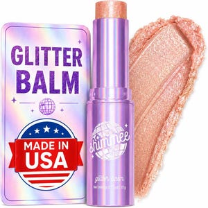 May include: A purple twist-up tube of glitter balm with a shimmering peach-toned product swatch. The packaging features the text GLITTER BALM, a disco ball icon, and a red banner stating MADE IN USA. The net weight is listed as 0.35 oz.