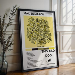 Könnte beinhalten: Ein gerahmtes Poster für das Album This Old Dog von Mac DeMarco mit einem gelben Mittelfeld voller schwarzer Strichzeichnungen, einer Titelliste mit dreizehn Liedern, dem Datum 5. Mai 2017 und einer Signatur in einem dünnen schwarzen Rahmen.