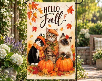 Op de afbeelding: Een rechthoekige tuin vlag met de tekst Hello Fall in zwarte schrijfletters. Het ontwerp toont drie katten met herfstaccessoires, waaronder een pompoenmuts en geruite sjaals, omringd door oranje pompoenen en rode esdoornbladeren.