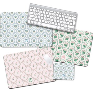 May include: A collection of patterned mouse pads and a keyboard. The mouse pads feature floral and bow designs in pastel colors, with personalized initials. The keyboard is silver and white.