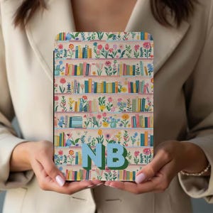 Könnte beinhalten: Eine E-Reader-Hülle mit floralem Bücherregal-Design, das bunte Bücher und Blumen zeigt. Die Hülle hat die Initialen "NB" in Blau und Grün. Die Hülle wird von einer Person gehalten.