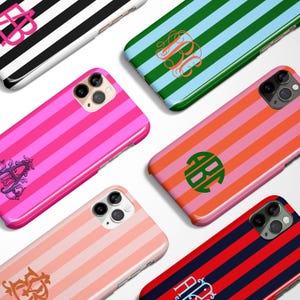 May include: A collection of phone cases with various striped patterns in vibrant colors, including pink, orange, blue, and black. Each case features a monogram design in a contrasting color, adding a personalized touch to the accessories.
