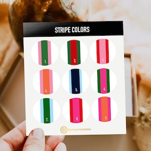May include: A card with the text "STRIPE COLORS" at the top. Nine oval designs with vertical stripes in various color combinations, including green, red, pink, orange, and blue. The "BOUTIQUE MONOGRAM" logo is at the bottom.