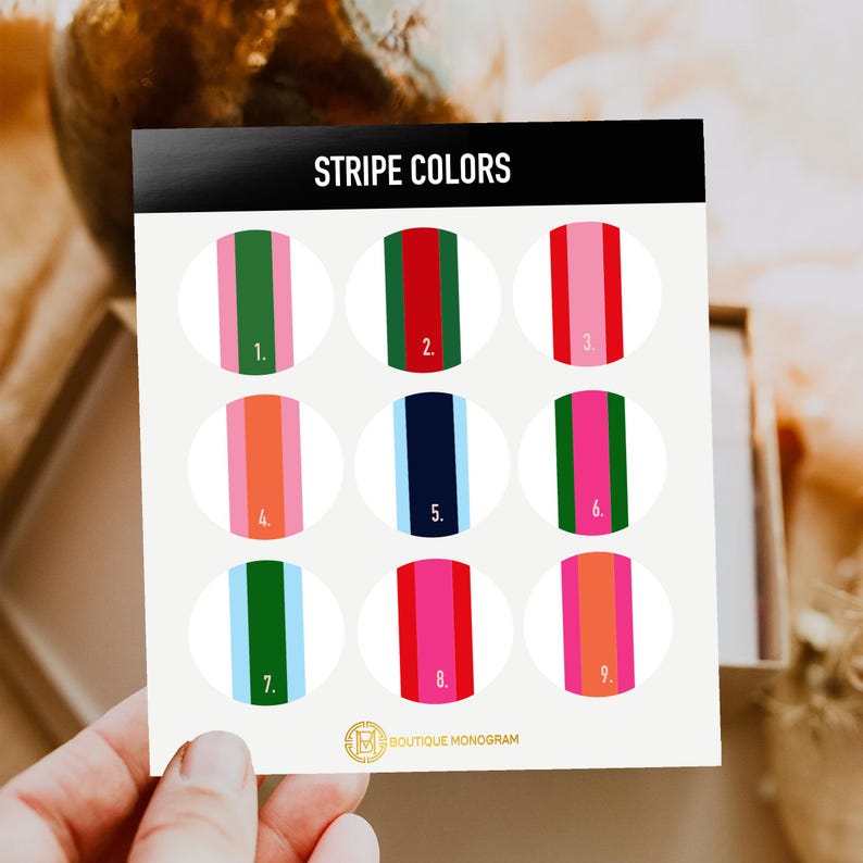 May include: A card with the text "STRIPE COLORS" at the top. Nine oval designs with vertical stripes in various color combinations, including green, red, pink, orange, and blue. The "BOUTIQUE MONOGRAM" logo is at the bottom.