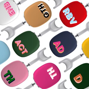 May include: A collection of 10 colorful round objects with different text on each. The objects are attached to white handles. The text on the objects includes: "RBV", "HIGH", "ENE", "ACT", "AD", "TH", "HT", "D", and two unreadable words.