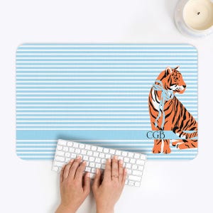 May include: A white ceramic mug with a black handle and the text "But First, Coffee" in a bold, black font. The mug is set against a blurred background, suggesting a cozy setting.