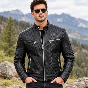 Könnte beinhalten: Eine schwarze Jacke mit texturiertem Schlangenledermuster, ausgestattet mit einem Stehkragen mit Druckknopf, einem durchgehenden silbernen Frontreißverschluss sowie zwei horizontalen Reißverschlusstaschen auf der Brust und zwei unteren Taschen.
