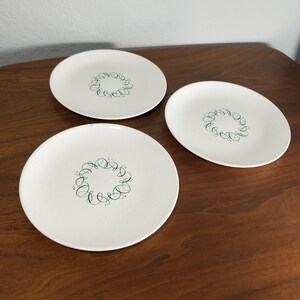 May include: Three white ceramic plates with a green and black swirl design.